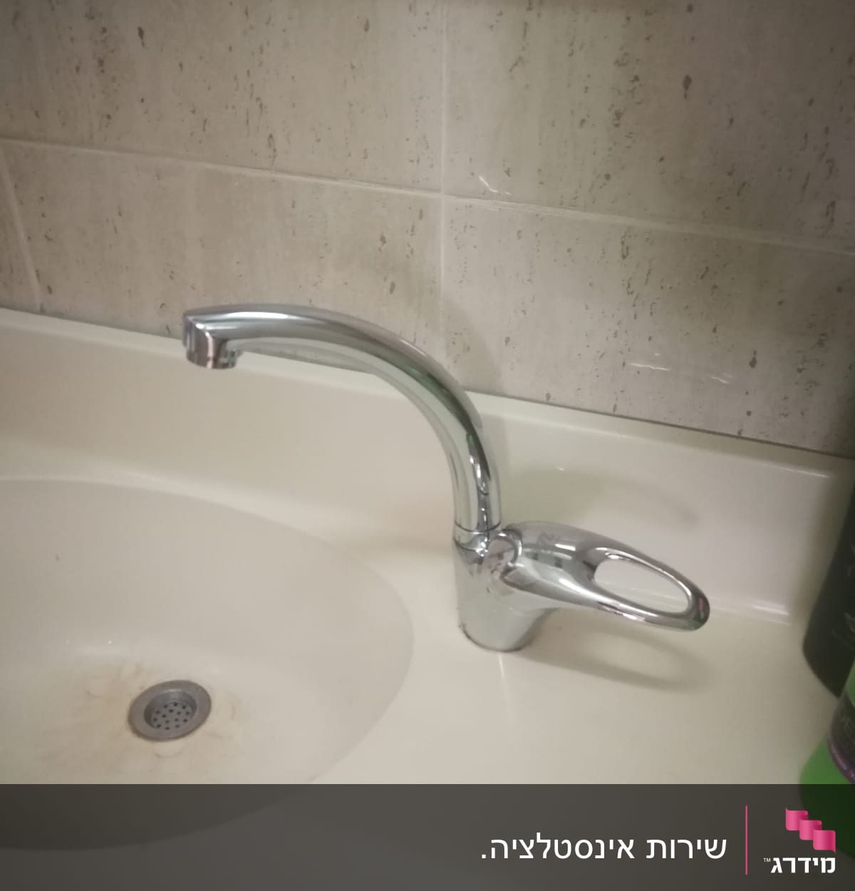 ברז כרום מותקן על כיור לבן עם כתמי חלודה